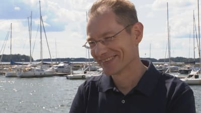 Jarkko Pajusalo, vd för Finnboat, står leende framför segelbåtar.