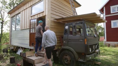David Roxendal och Matias Jungar på väg in i ett mikrohus på ett lastbilsflak.