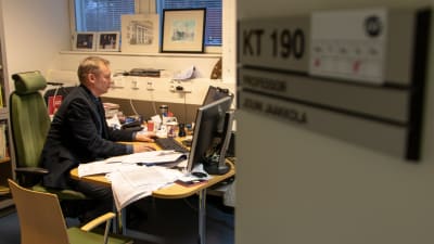 Professori Jouni Jaakkola työhuonneessaan tietokoneen ääressä
