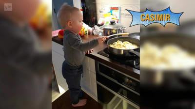 En liten pojke som heter Casimir står på en pall vid spisen och hjälper till med matlagningen