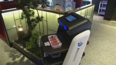 En robot serverar mat på en restaurang i Kina