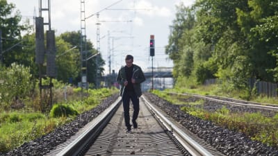Markku Laakso går längs järnvägsspåret