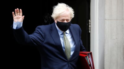 Storbritanniens premiärminister Boris Johnson bär munskydd då han lämnar sin tjänstebostad i London.