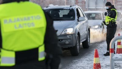 Gränskontrollanter och en rad bilar. 