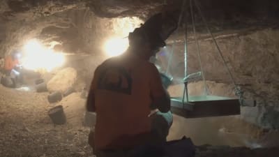 Inne i grottan arbetar arkeologerna med tusentals år gamla lämningar