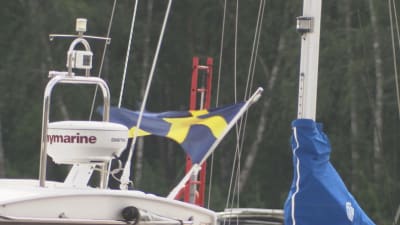 En närbild på en fritidsbåt med svenskt flagg.