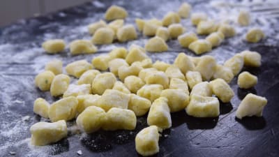 Potatisklimpar på ett mjölat bord