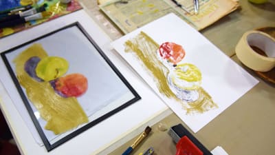 En glasskiva där man målat två äppel och ett pappersark där målningen är avtryckt, en så kallad monprint..
