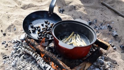 Ekollon och vassrötter tillreds över öppen eld.