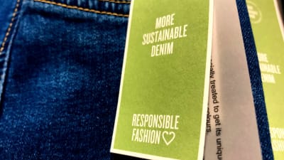ett jeansplagg med en lapp som talar om att det är hållbart mode