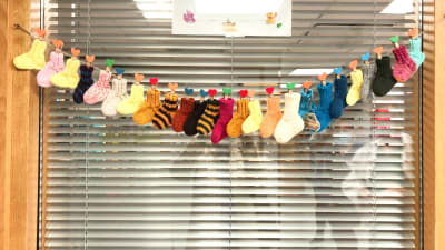 En rad med sockor på Lojo bb som visar hur många barn som fötts på avdelningen den månaden.