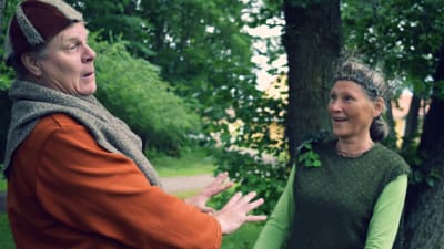 Yngve Källberg och Vivi-Anna Rehnström agerar mot varandra i sina teaterkläder i en grön park.