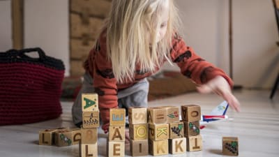 Barn leker med leksaksklossar.