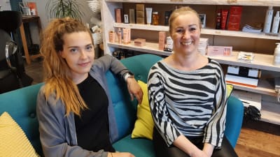 Två damer i en soffa i en frisersalong