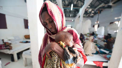 En mormor med sitt udnernärda barnbarn på Kismayo General Hospital’s Stabilization Centre