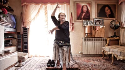 La Chana dansar flamenco sittandes i sitt vardagsrum.