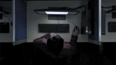 En av innehållsmoderatorerna fotad uppifrån med datorskärmens ljus i ansiktet.