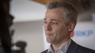 En medelålders i kortklippt grått hår. 
