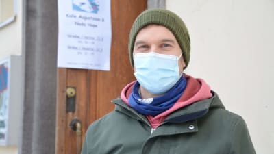 Mikko Söderström framför svenska församlingshemmet med munskydd på. 