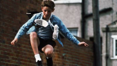 Billy Elliot (Jamie Bell) hyppäämässä ilmaan balettitossut kaulan ympäri kietaistuna.