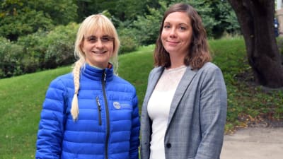 Saija Westerlund-Cook och Janina Andersson står ute i en grön park.