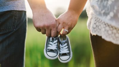 föräldrar hållar i babyskor