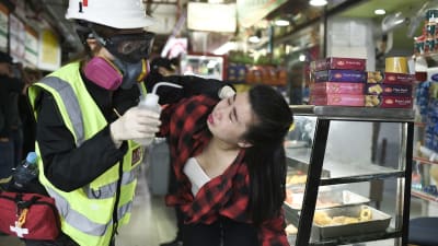 En kvinna som fått tårgas i ansiktet får första hjälpen