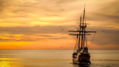 Ett segelfartyg från 1800-talet seglar mot solnedgången