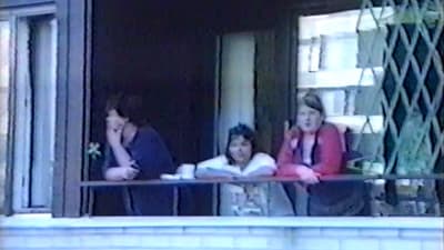Bild på publik som följer med gisslandramat i Borgå 2002 från balkongen i grannhuset