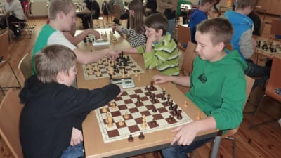 skolelever spelar schack