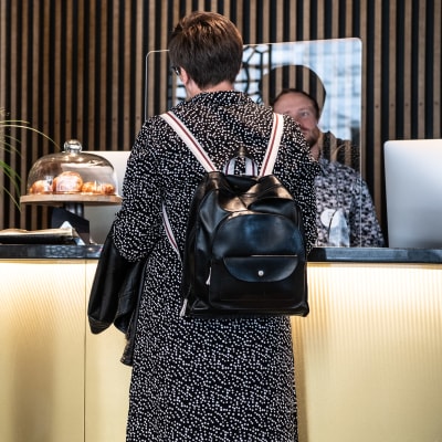 Kvinna bakifrån vid en hotellreception.