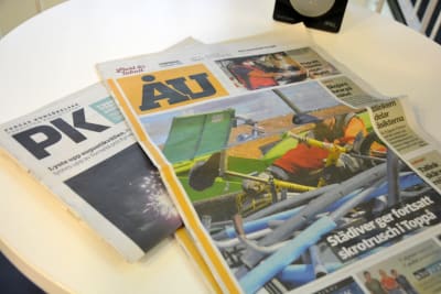 Tidningarna ÅU och Pargas kungörelser på ett bord.
