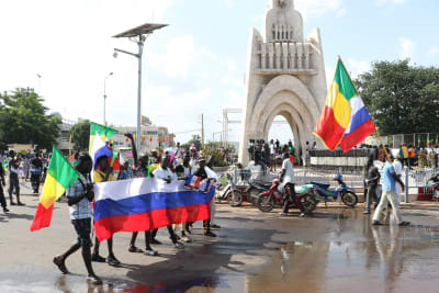 Mielenosoittajia, jotka kantavat Malin ja Venäjän lippuja.