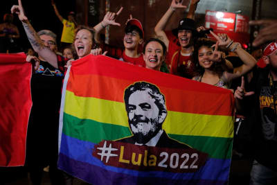 Brasiliassa Luiz Inacio Lula da Silvan kannattajat pitelevät väkijoukossa sateenkaarilippua, jossa on Lulan kuva.