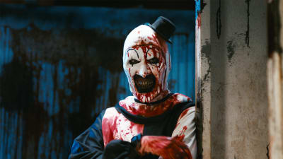 Art the Clown (David Howard Thornton) i närbild där hen står lutad mot en vägg och är helt nerblodig.