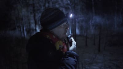 Historioitsija Teemu Keskisarja kävelee pimeässä metsässä otsalamppu päässään ja puhuu nauhuriin.
