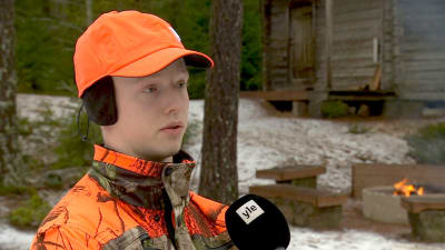 En ung jägare i orange jaktkläder och mössa. 