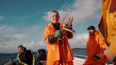 En norsk fiskare med en hummer i handen.