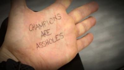 Emilia Soini has written the text Champions are assholes on her hand with a black pen.