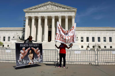 två demonstranter utanför USA:s högsta domstol i Washington.