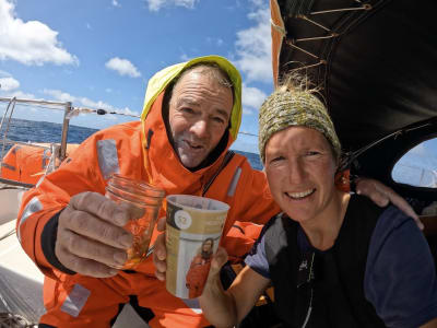 Tapio Lehtinen och Kirsten Neuschäfer håller i var sitt glas ombord en segelbåt.