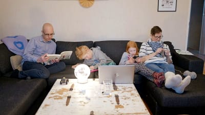 Andreas sitter i en stor soffa tillsammans med sin fru Heidi som stickar och deras två gemensamma barn som gör läxorna.