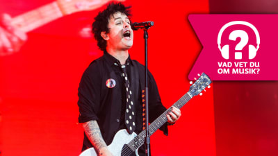Billie Joe Armstrong från gruppen Green Day spelar gitarr på scen.