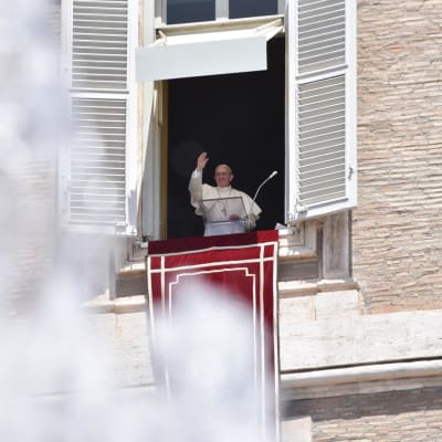 Påven Franciskus hälsdar från en balkong.