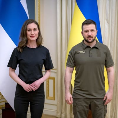 Sanna Marin och Volodymyr Zelenskyj framför sina länders flaggor.
