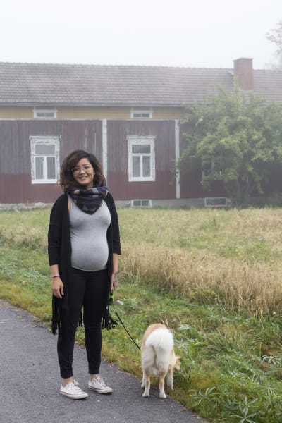 Emilia Jansson står på en väg tillsammans med sin hund.