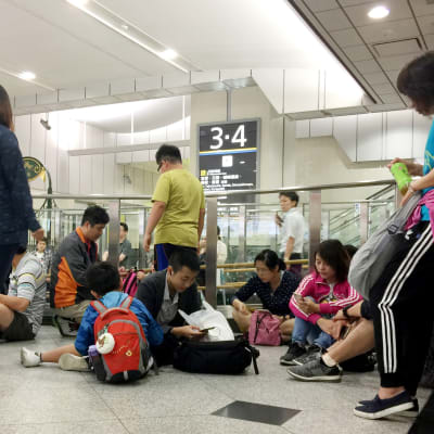Passagerare på järnvägsstationen Shin-Osaka väntar på att trafiken ska återupptas efter skalvet den 18 juni 2019.
