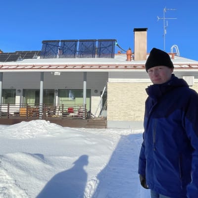 Mika Ruusunen seisoo suunnittelemansa energiatehokkaan talon takapihalla.