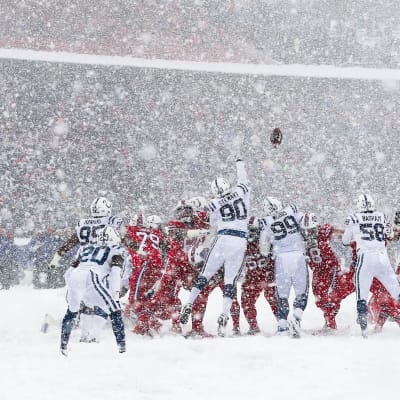 Pelaajat tavoittelevat palloa lumimyräkässä.