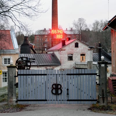 Porten till Billnäs bruk där en röd, stor digital klocka finns.